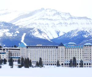 View of the Fairmont Chateau in Lake Louise, Canada backdropped by snow-capped peaks. 