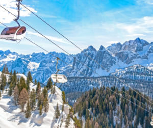 View from below a ski lift at Cortina ski resort backdropped by the Dolomites in winter.