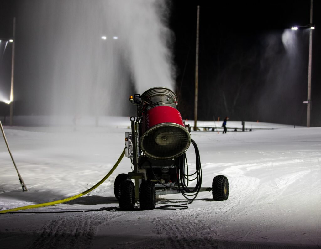 A snow machine making snow by compressing supercooled water and blowing it out into the air. 